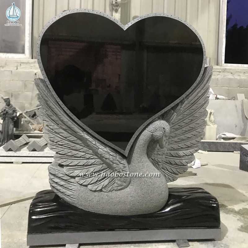 Lápide fúnebre de granito preto em forma de coração cisne esculpida
